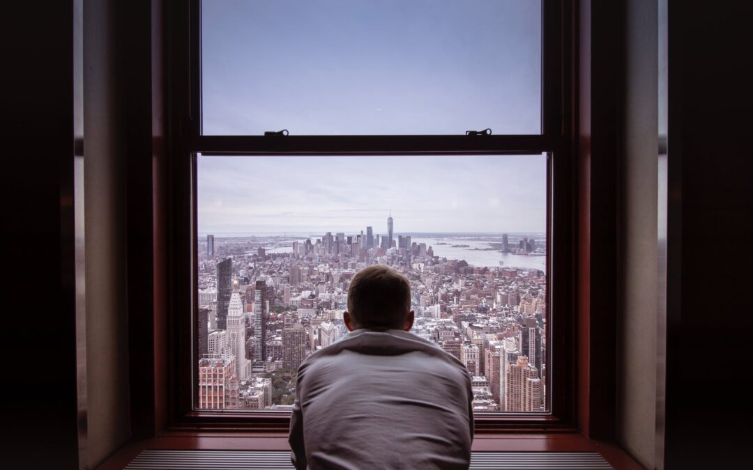 man in gray shirt looking at city buildings